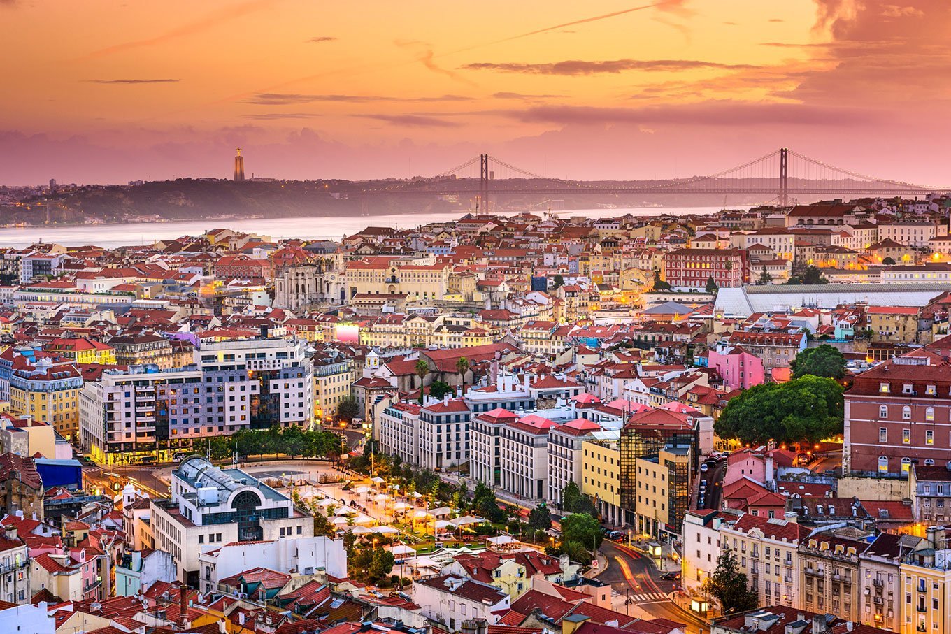 Vue panoramique de Lisbonne au coucher du soleil, avec les toits de la ville, le Tage et le pont du 25 Avril